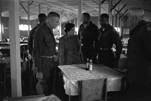 Soldiers waiting by table inside dining hall