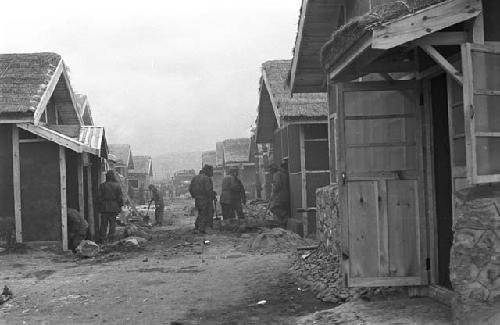 Portrait of workers digging ground outside of houses