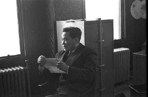 Man wearing suit sitting in chair holding note card 3