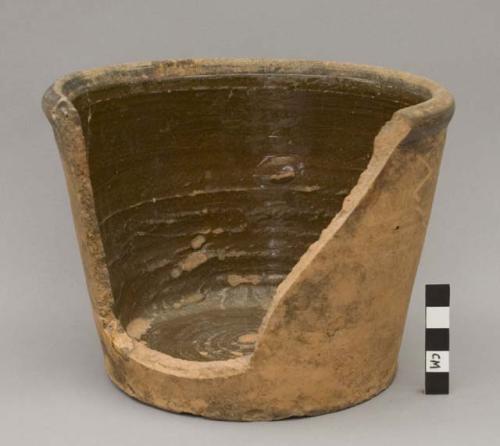 Clay pot with steep sides.  Brown glaze in the interior of the pot.