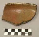 Restored rim sherd of shallow red pottery vessel decorated with black and white