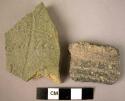 2 potsherds -- 1 with gooving, 1 with an incised pattern