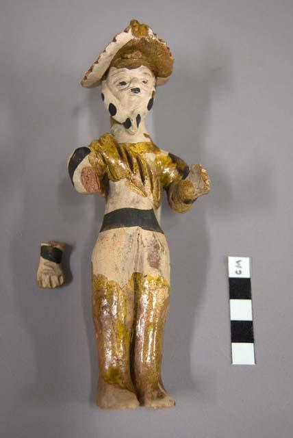 Figurine of human wearing hat and yellow sash