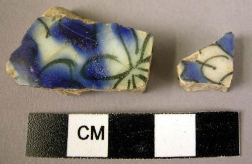 2 potsherds - blue and black on white glaze