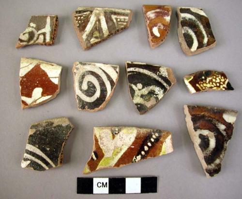 21 rim potsherds - glazed, white on dark brown (local)