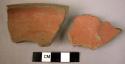 2 potsherds - red slip inside and out, polished; maedum dark gray paste;