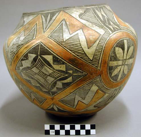 Polychrome jar. Orange and black geometric and curvilinear designs on whit