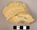 Potsherd - yellow-buff slip?; finer paste; wheelmade