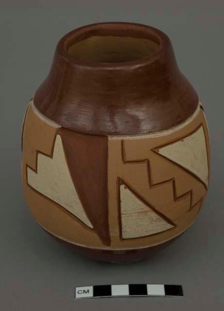 Carved jar; tan, dark brown and white design