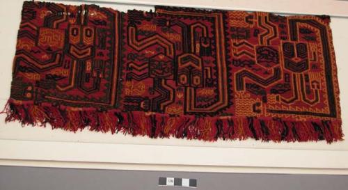 Organic, woven border of mantle, depicts colorful anthropomorphic figures