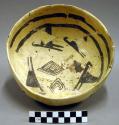 Black on yellow pottery bowl--restorable?