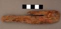 Piece of ironwood, one end rounded, other end with 2 notches. l: 13.7 cm.