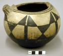 Small pottery vessel. Flat base, globular, incurved rim, black design on cream