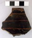 Ceramic rim sherd, black, incised horizontally, red pigment