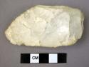Cast of chipped stone edged tool, scraper or small hand axe, white, broken