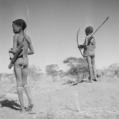 Two boys carrying bows and quivers