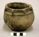 Ceramic vessel, complete, 8 small lugs around rim, incised below lugs, repaired