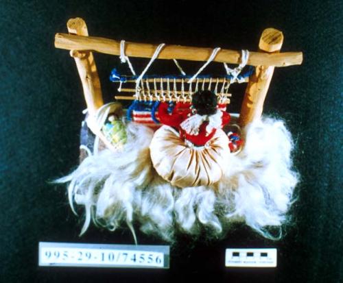 Miniature loom scene with weaver and textile of American flag