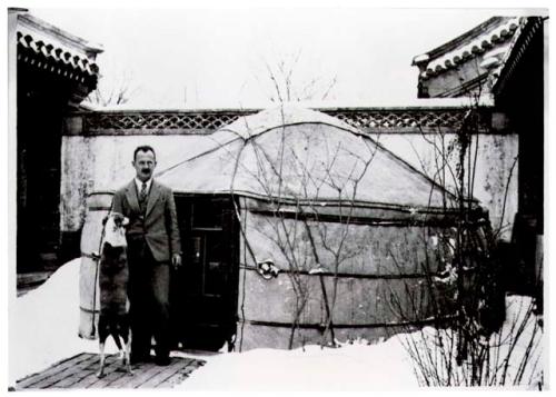 Owen Lattimore in front of yurt in snow-covered courtyard