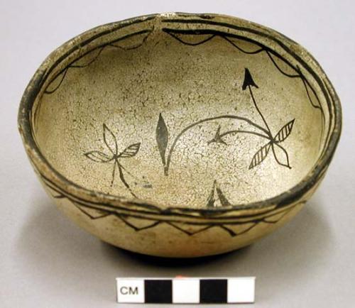 Small pottery bowl. Greyish slip over red. 2 straight lines and zig-zag along