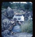 Boat next to rocky shore of the Okavango River