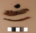 Fiber fragments, possibly pine needles; charred wood fragments