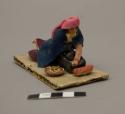 Wax figure of woman grinding corn - "moledora de granos"