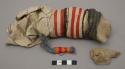 Child's doll - clay wrapped with cloth and red, brown, and white