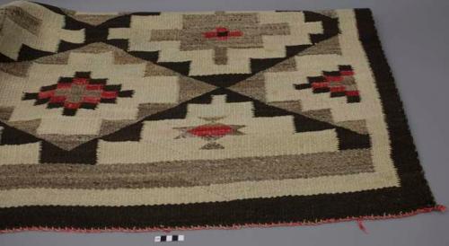 Rug; undyed dark brown and off-white wool with dyed red wool