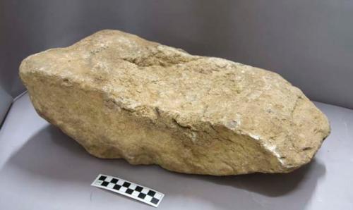 Ground stone, pitted grinding stone fragment