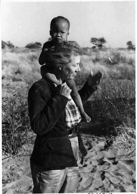 Lorna Marshall carrying N!whakwe on her shoulders