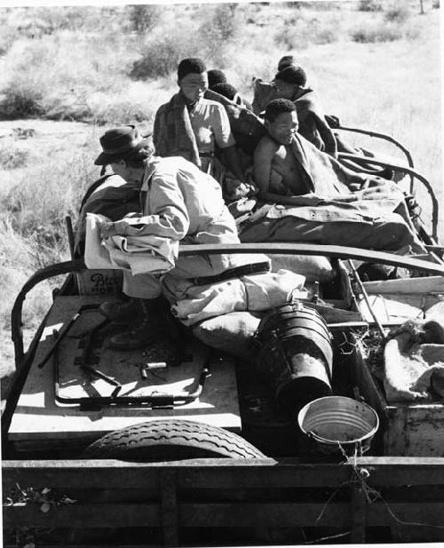 Group of people sitting on top of the expedition truck, including !Ungka, "/Qui Navel" and Lorna Marshall