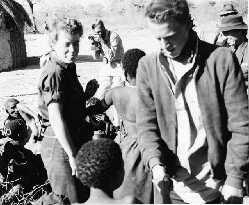 Group of people sitting and one person standing with Elizabeth Marshall Thomas and John Marshall, with Daniel Blitz in the background