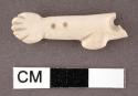 Shell, carved effigy fragment of hand, arm and sleeve, with two partial perforat