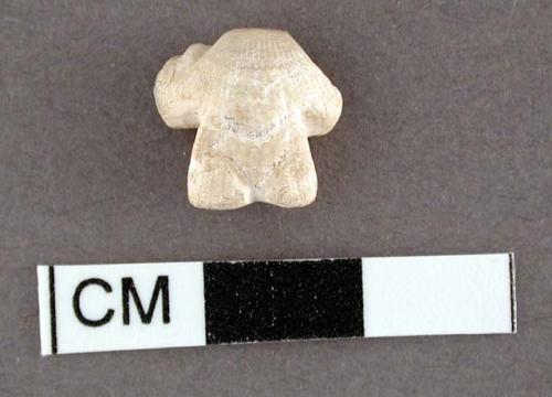 Fragment of carved glycymeris shell. 1.1 x 1 cm.