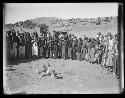 Circle of tribal people around chickens