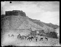 Man and pack animals in front of ruins