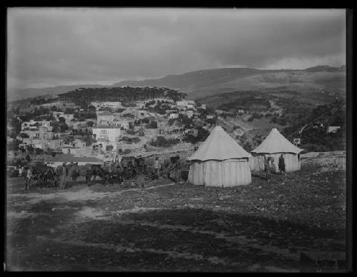 Tents, men, and animals on hillside