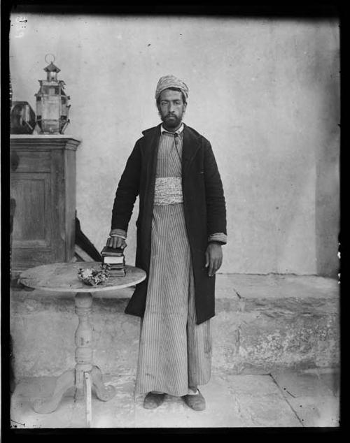 Man standing next to table with hand on books