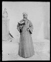 Man in traditional dress holding a book