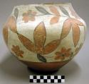 Polychrome jar. Floral designs around body and neck. Black and orange on white