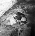 Two men sit at excavation site