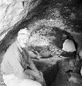 Two people sit down at excavation site