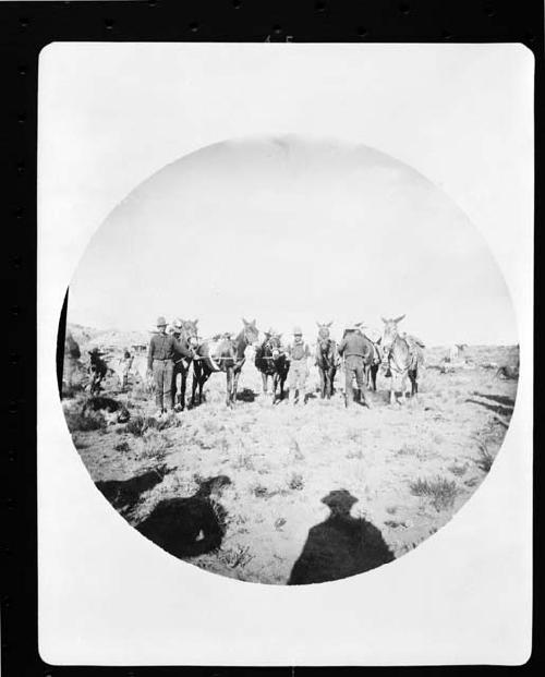 Men standing with pack horses