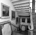 Paintings hang on the walls of a staircase