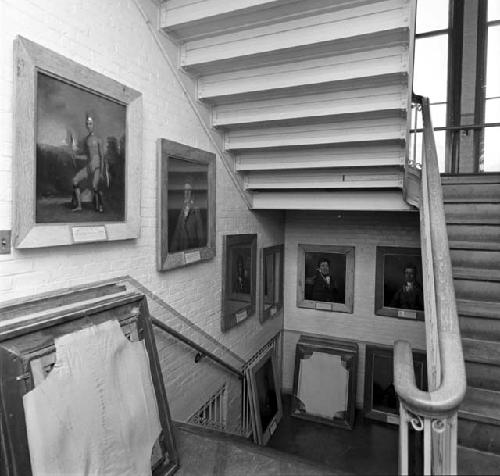 Paintings hang on the walls of a staircase