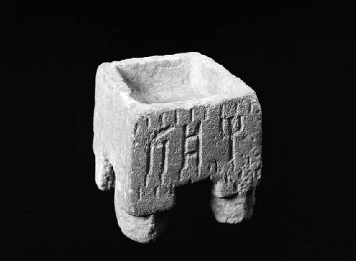 Square stone container with etchings and four legs