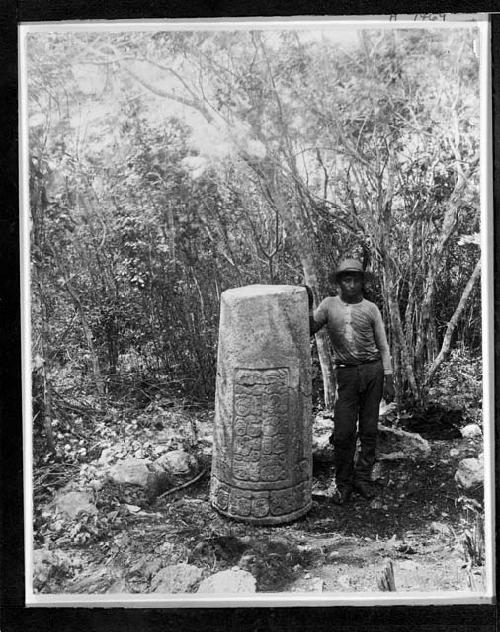 Man stands next to stela