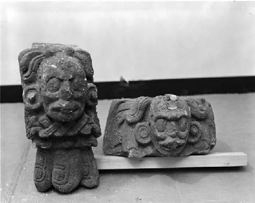 Two carved stone objects with faces