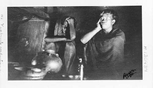 Two priests conducting a religious ceremony in a dwelling